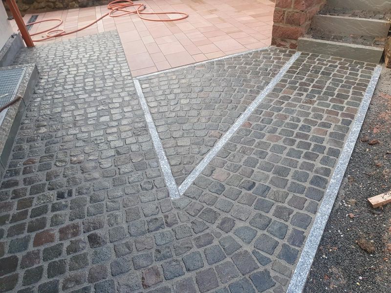 Kopfsteinpflaster mit eingelegten Plattenbändern