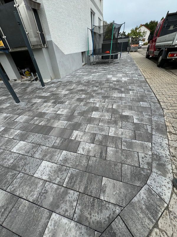 Weg mit grauem Pflaster und Randeinfassung