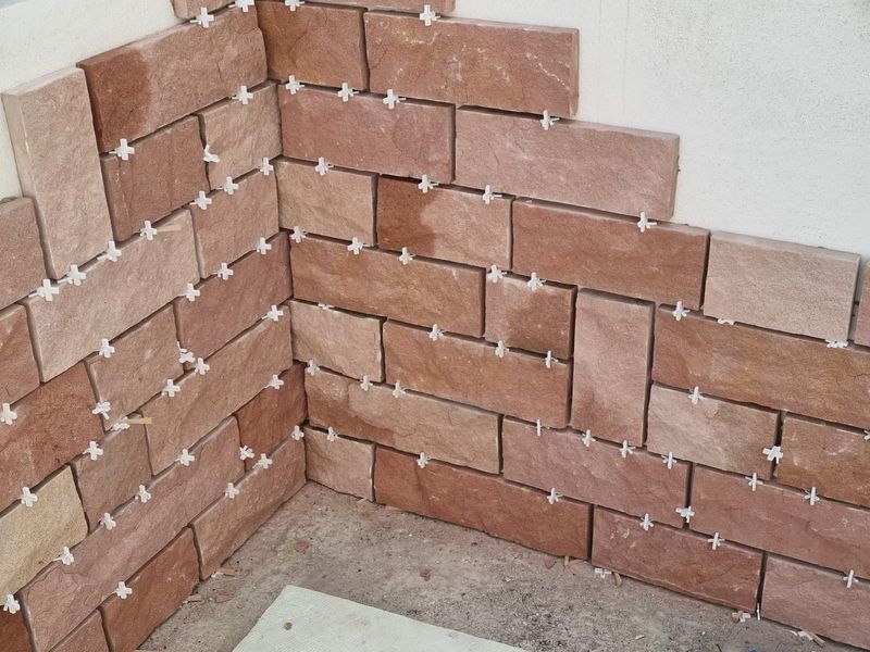 Wandbekleidung aus Sandsteinriemchen während der Verlegung