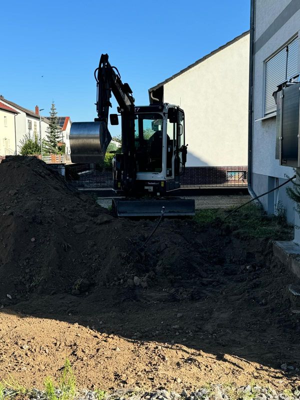 Minibagger bei Erdarbeiten am Haus