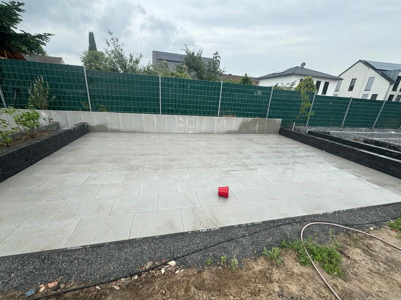 Neue Plattenfläche im Garten mit Sichtschutzzaun