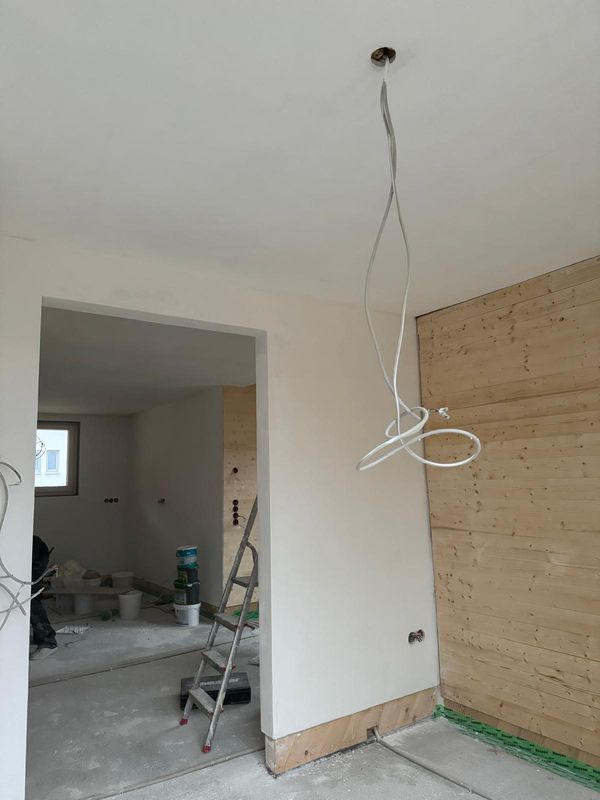 Raum mit Holzwand und frisch verputzten Wänden