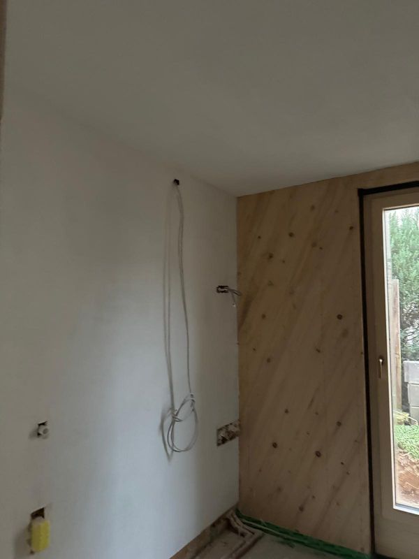 Holzbekleidung neben verputzter Wand